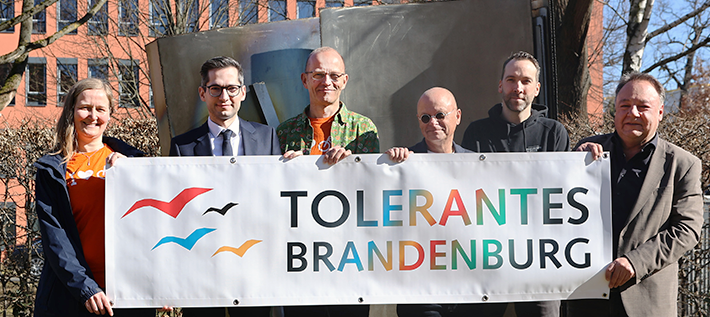 Annedore Althausen (ADFC), Staatssekretär David Kolesnyk, Christian Wessel (ADFC), Frank Stieldorf und Hilmar Hilger (beide von der Rheinsberger Preussenquelle) sowie Alfred Roos, Referatsleiter Koordinierungsstelle „Tolerantes Brandenburg“ halten das Logo der Koordinierungsstelle hoch
